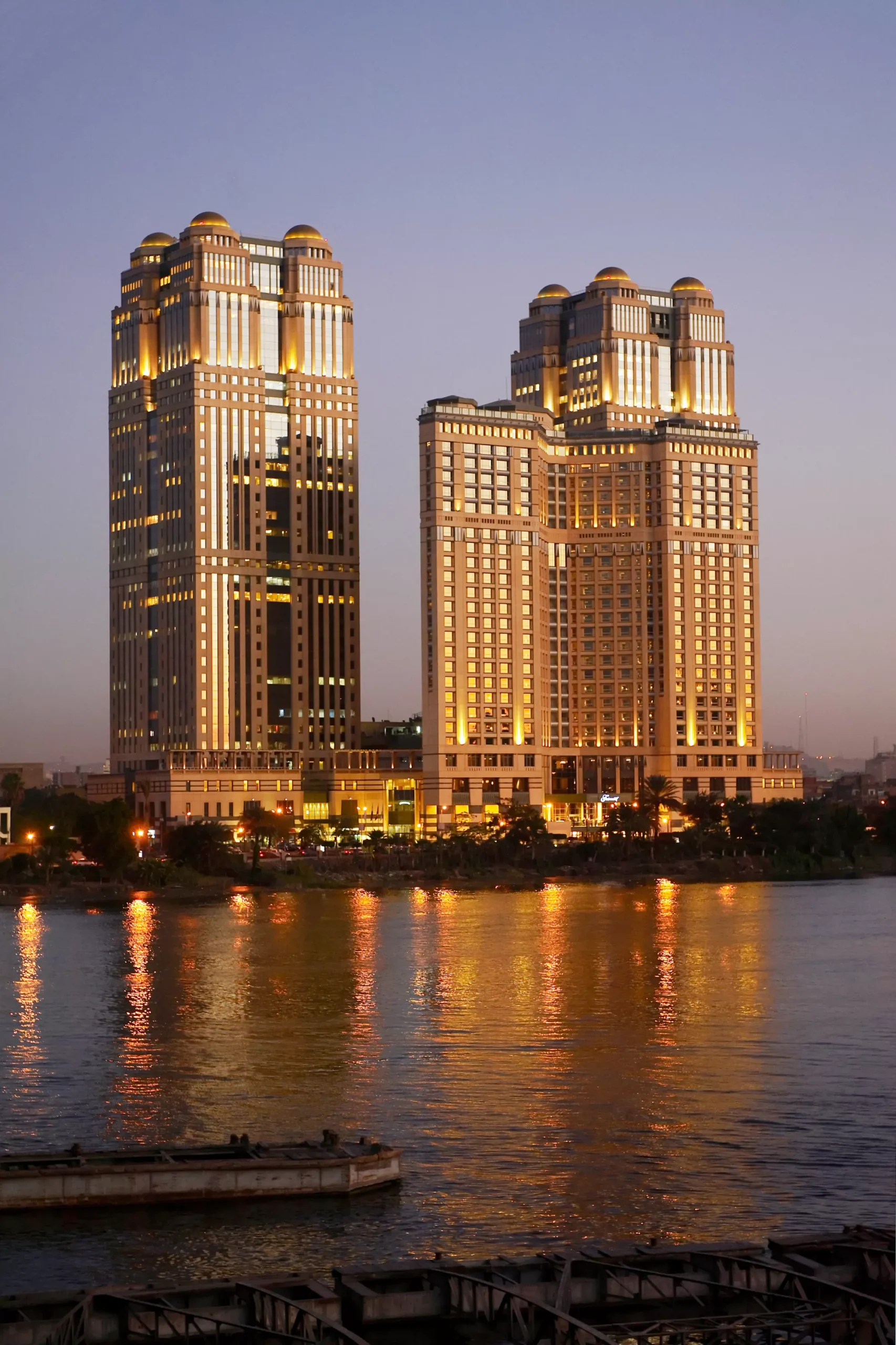 Fairmont Nile City towers lit up at night on the Nile